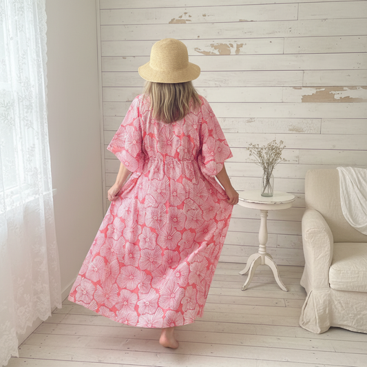 Woman walking away in coral lilypad kaftan shabby chic setting
